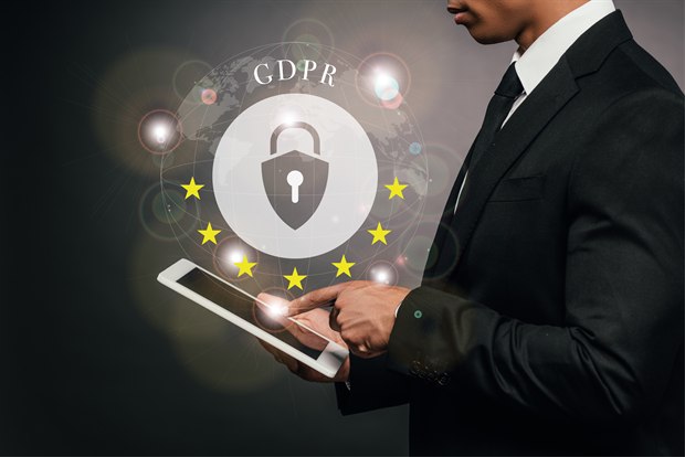 איש עסקים מחזיק מסך לצד מנעול GDPR מוקף בכוכבי האיחוד האירופי.